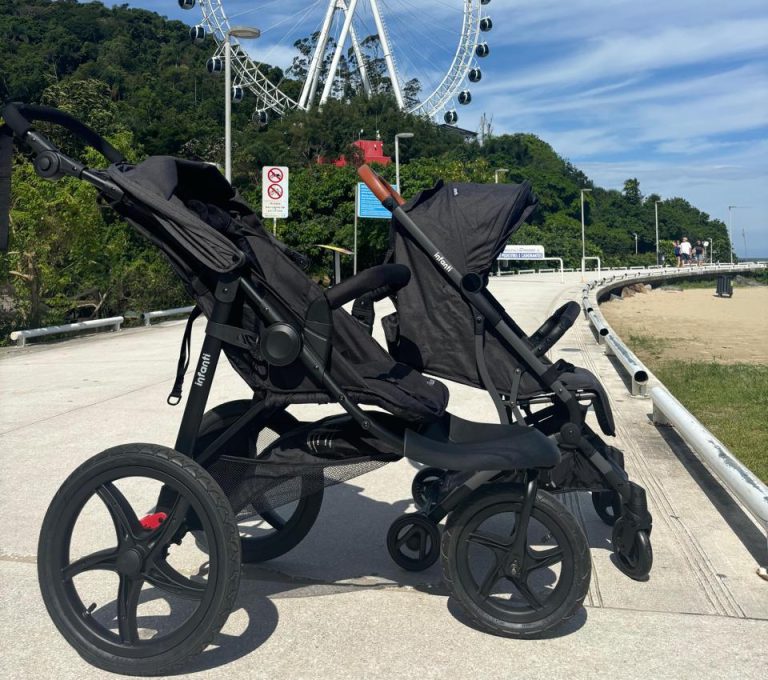 Imagem de um carrinho de bebe na areia da praia de balneario camboriu com a roda gigante ao fundo